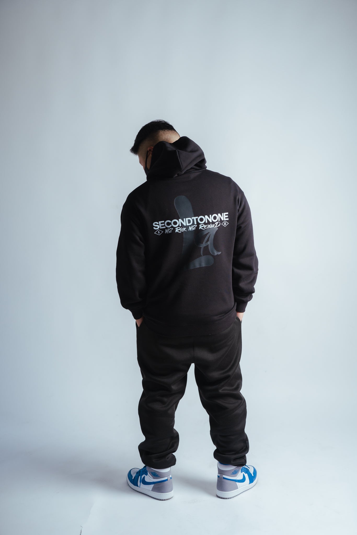 male model showing the back graphic of the no risk hoodie