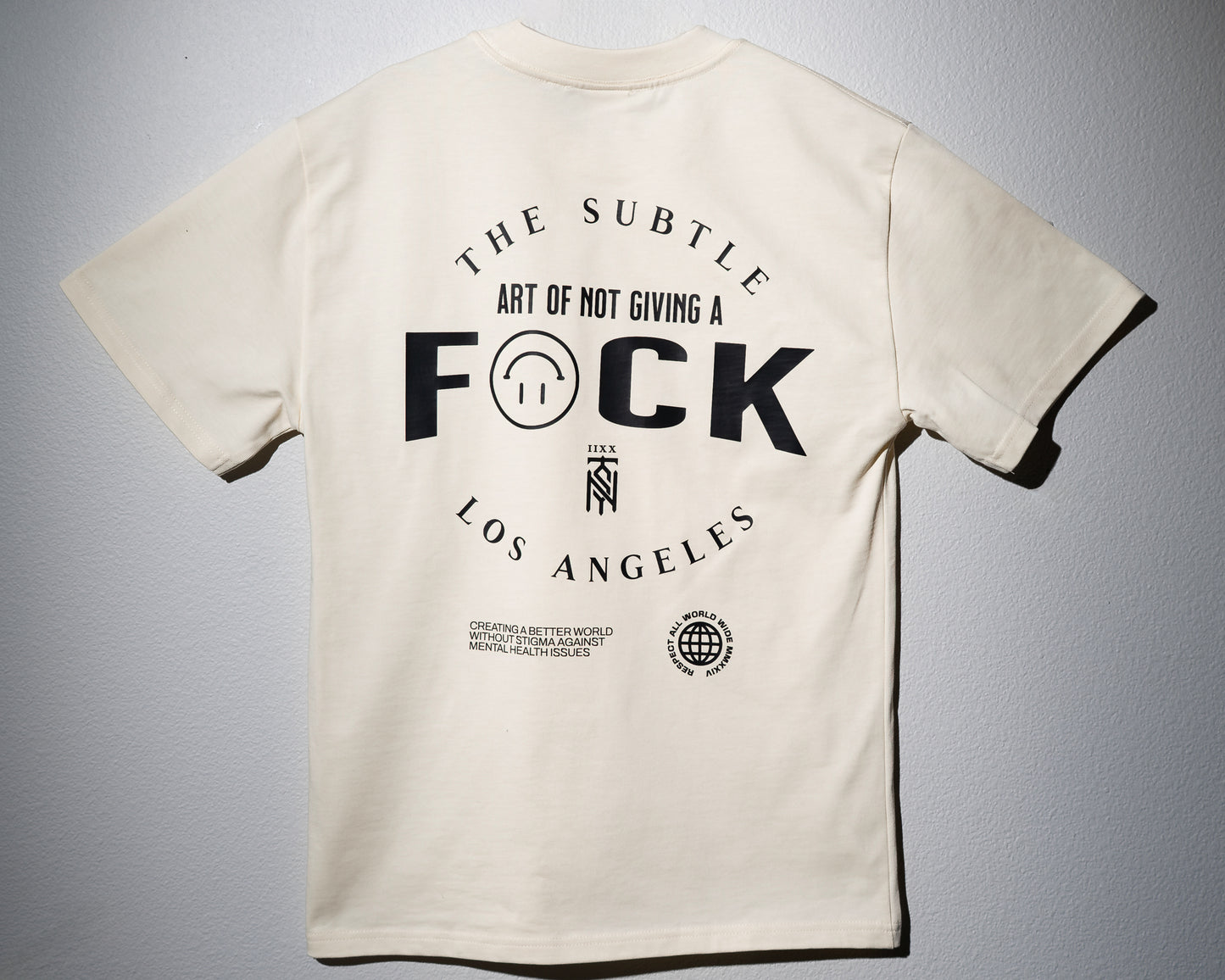 a heavyweight tee in a tan color with a large graphic print that says the subtle art of not giving a f-word